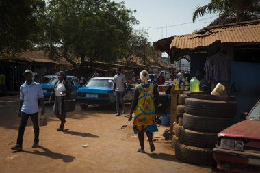 Bissau, Gine Cumhuriyeti - 29 Ocak 2018: mahallede, Gine Bissau, Batı Afrika toprak yol boyunca yürüyüş insanlarla Bissau şehir sokak sahne