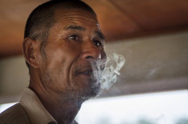 Yangshuo, Çin - 2 Ağustos 2012: Bir sigara Yangshuo Çin ' Li Nehri bir tekne bir Çinli portresi.