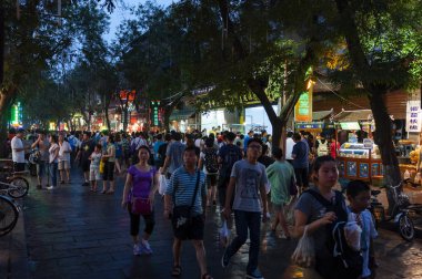 Xian, China - August 5, 2012: People walking in a street of the Muslim Quarter in the city of Xian at night, in China, Asia clipart