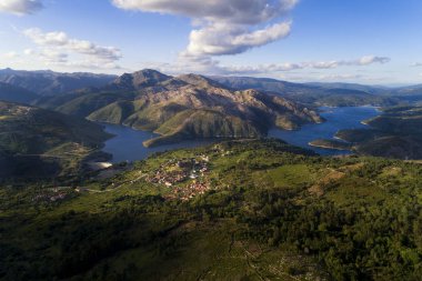 Aerial panoramic view of the historic village of Lindoso, with the surroundings mountains and lake, at the Peneda Geres National Park, in Portugal. clipart