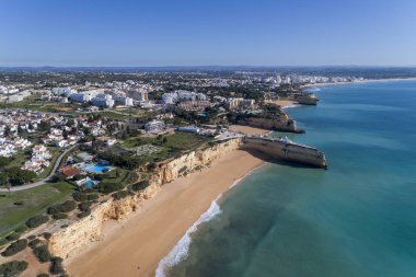 Porches boyunca Nova ve Senhora da Rocha plajları ve arka planda Algarve, Portekiz 'deki Armacao de Pera ile birlikte güzel kıyı şeridinin insansız hava aracı fotoğrafı.