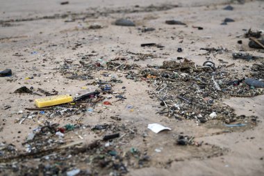 Plastik ve mikro plastik çöpler Güney Portekiz 'deki bir plajda dalgaların çekildiği bir plajda yıkanır..