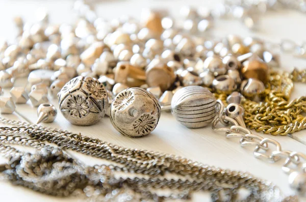 Close-up van gouden kettingen en Colliers. Hand gemaakt metalen sieraden elementen plat leggen — Stockfoto