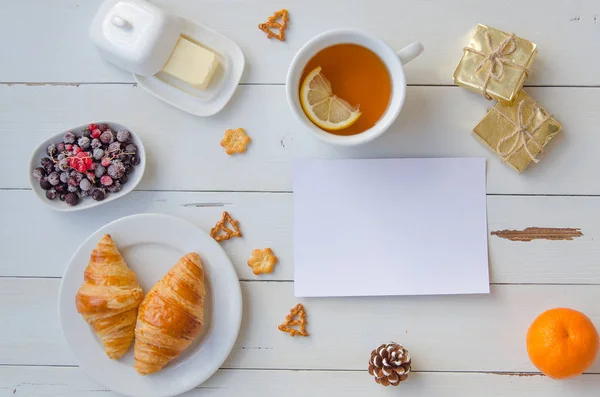 Desayuno de croissants calientes, mantequilla, té y grosellas en mesa de madera. Puesta plana — Foto de Stock