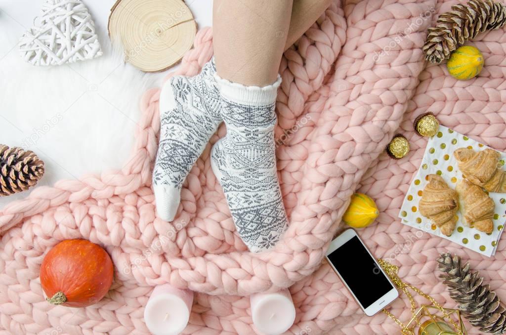 Girl legs in a socks on Merino wool blanket, trendy concept. Close-up flatly