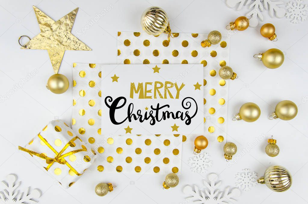 Christmas card flatlay background with golden balls and christmas decorations Merry christmas lettering.