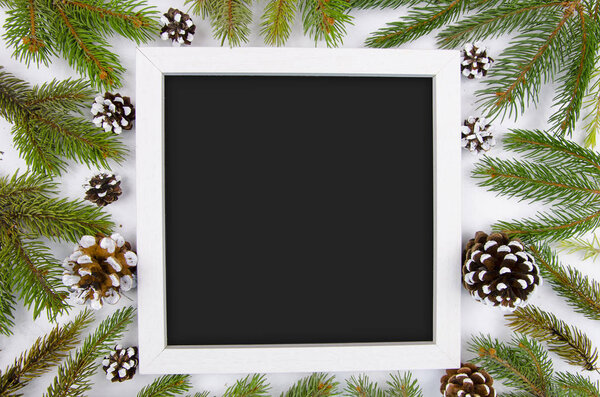 Christmas frame with fir branches and cones. Trendy mockup copy space. Flat lay Happy new year flat lay on white wooden background. Top view