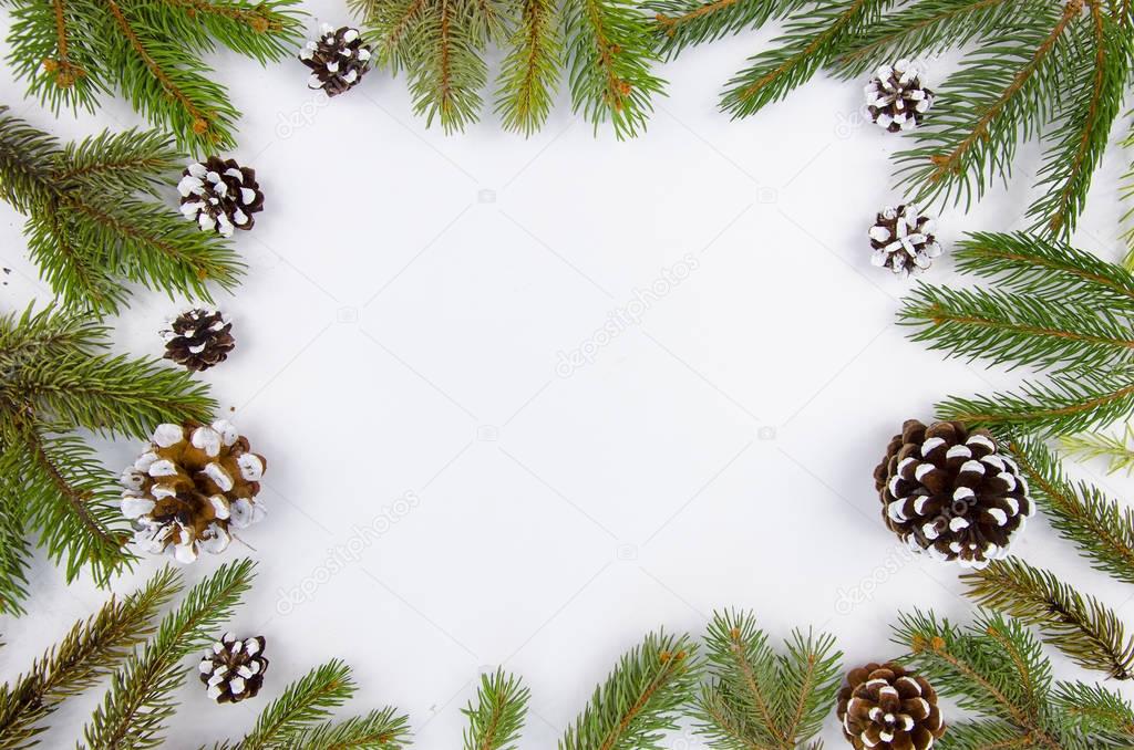 Christmas frame from fir branches and cones. Flat lay Happy new year composition on white wooden background. Trendy mockup copy space. Top view