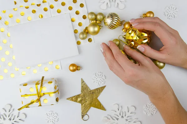 Mulher segurar bolas de Natal de ouro nas mãos e prepare-se para decorar a árvore de Natal.Flat lay, vista superior. Feliz cartão de felicitações de Natal. Feliz maquete de Hollidays — Fotografia de Stock