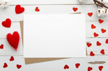Boş beyaz kağıt levha kırmızı kalpler ile ahşap arka plan üzerinde. Üstten Görünüm. Düz yatıyordu. Aşk mesajı