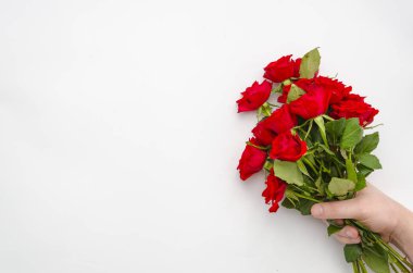 Beyaz arka plan üzerinde izole kırmızı gül demet tutan adam el. Sizin yazı için iyi mockup