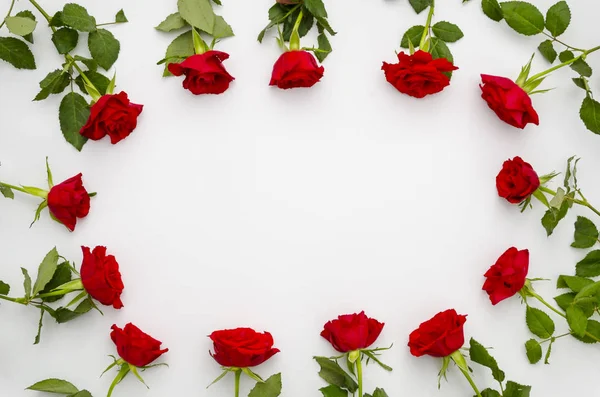 Ημέρα του Αγίου Βαλεντίνου ή επέτειος κόκκινα τριαντάφυλλα πλαισιωμένο γύρω από κενό μήνυμα χώρο για το κείμενο ή την εικόνα σας. Σκελετός όμορφο κόκκινο bouquete με αντίγραφο χώρο στη μέση. Επίπεδη lay κοροϊδεύω — Φωτογραφία Αρχείου