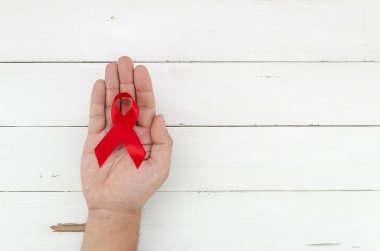 Beyaz tahta arka planda erkek eli kurdelesi ve yazı için yeri var. 1 Aralık Dünya Yardım Günü konsepti