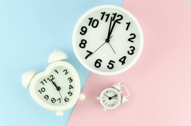 Üst manzara beyaz retro güzel çalar saat, kalp şekilli saat ve mavi ve pembe pop pastel renk geometrik arka plan üzerindeki duvar saati. Zaman tükeniyor.