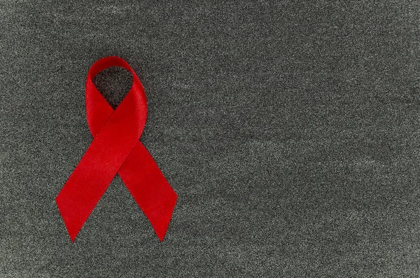 Plocha ležela Červená stuha Hiv, AIDS den 01 Prosinec koncept na šedé farbric textilní pozadí mockup s prostorem pro text — Stock fotografie