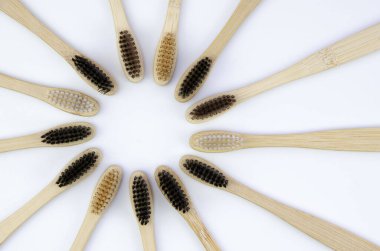 Üst manzara ahşap bambu diş fırçaları, çevre dostu ve plastiksiz. Beyaz zemin üzerinde düz yatıyordu, çember şekli sıfır atık