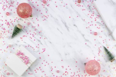 Noel düzleştirici kompozisyon. Noel baloları, pembe süslemeler ve beyaz bir arka planda hediye kutusu. Boş boşluklu çerçeve