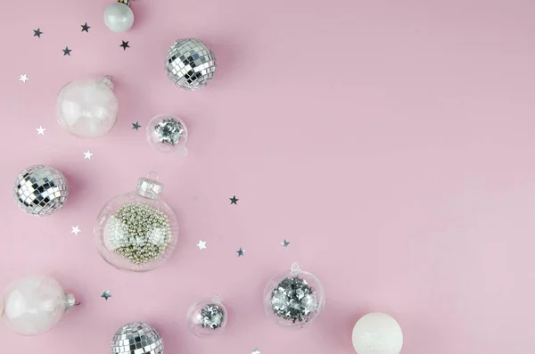 Enfeites de Natal rosa e prata fundo decorações. Brilho de prata moderno, bolas de bugigangas de vidro transparente e branco em cantos fronteira horizontal com espaço de cópia em um fundo rosa — Fotografia de Stock