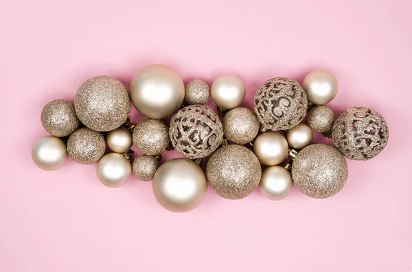 Kerstcompositie maate gouden ballen en kerstversieringen op een roze achtergrond. Bovenaanzicht vlak lay — Stockfoto