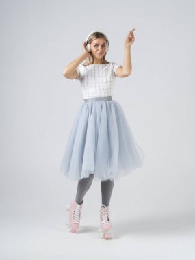 Pembe retro patenli top model kadın müzik dinliyor ve beyaz arka planda dans ediyor.