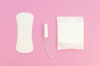 Pembe düz gübreli, kadınsı pedler ve pembe arka planda tamponlar. Adet döngüsü fikri