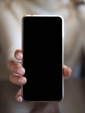 Dikey kadın el ele tutuşması ve cep telefonunu boş siyah ekranla gösterme. Tam ekran mobil konumu ya da uygulama için alanı kopyala