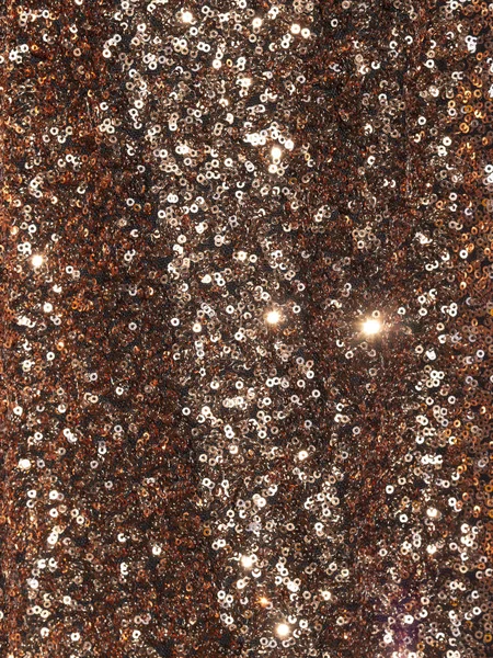 Rose gold sparkle glitter background. Crumpled fabric with glittering sequins texture