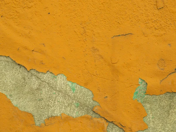 Yeso naranja despegando de una vieja pared de hormigón. Textura de primer plano de la caída de escamas de pintura —  Fotos de Stock