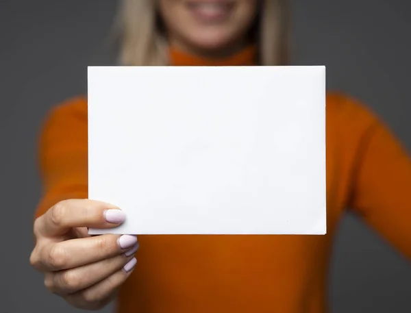 Um sorriso adolescente menina detém grande papel branco folha mockup com espaço para o seu texto — Fotografia de Stock