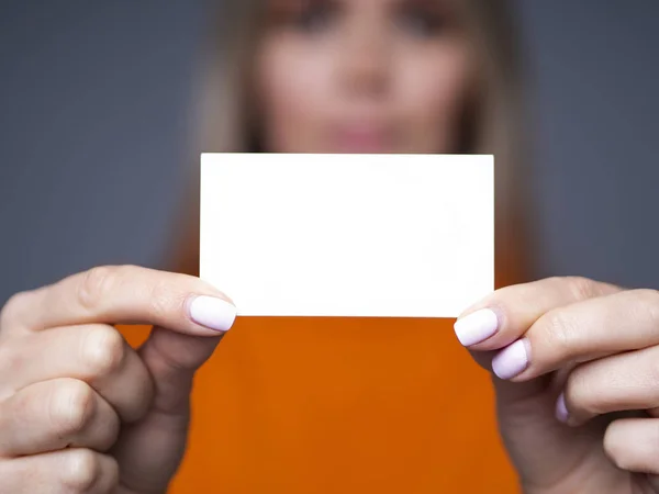 Mockup front view cartão de visita em mãos femininas e rosto borrado com espaço para o seu design — Fotografia de Stock