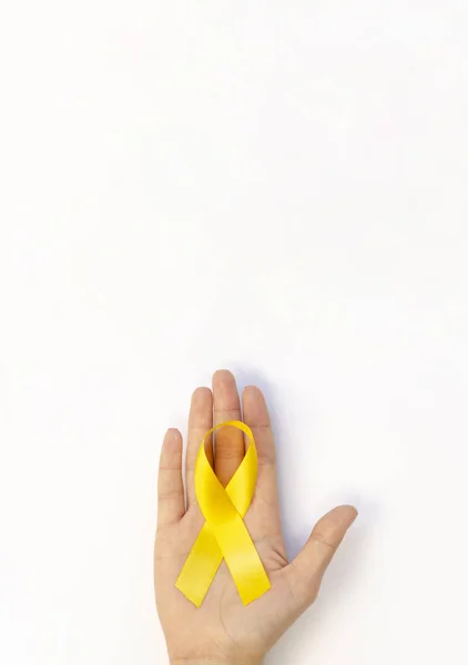 Cartel vertical con cinta amarilla en la mano. Copia del espacio para el banner del día de concientización sobre el cáncer infantil —  Fotos de Stock