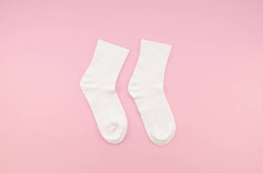 Düz bir çift beyaz pamuklu çorap, pastel pembe arka planda yatıyordu. Üst manzara çorapları coşturur