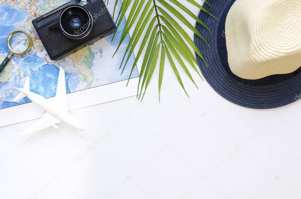 Top view travel mockup white table with straw hat, palm branch, vintage camera and map. Flat lay travel blogger concept