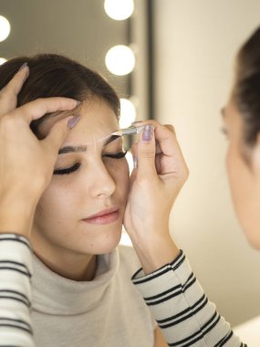 Mikro patinaj ve kaş mimarisini kapatın. Beyaz kalemle yeni kaş çizgisi çiz