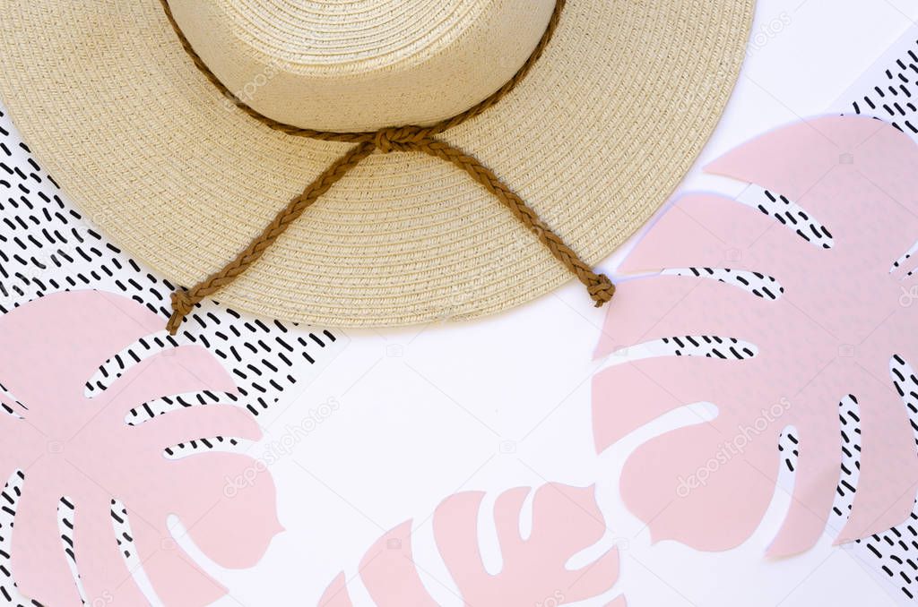 Flat lay straw hat and Handcrafted Papercraft palm leaves and geometric background. Summer minimal concept