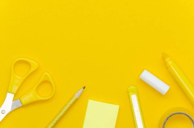 Sarı arka planda sarı çerçeveli okul malzemeleri. Kopyalama alanı olan kırtasiye kenarı