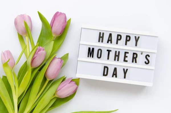 Caja de luz del Día de las Madres con coloridas flores de tulipán sobre un fondo blanco. Vista superior — Foto de Stock