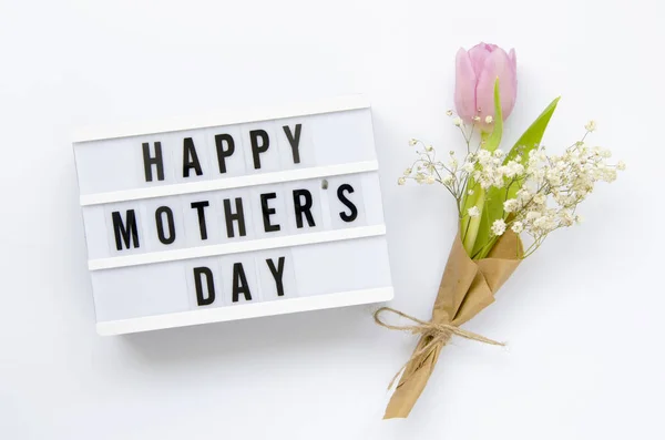 Caja de luz con signo Feliz Día de las Madres y ramo de flores aislado en blanco. Vista superior — Foto de Stock