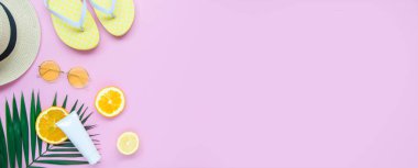 Yaz plajı ve tropikal meyve arka planı. Üst sınır çerçevesi fotokopi alanı, güneş kremi, palmiye yaprağı ve şapka. Uzayı pembe arkaplanda kopyala