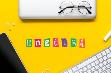 Sarı arka planda gümüş defter, şık gözlükler ve tablet bilgisayar çerçeveli ENGLISH işareti. Kendini Karantina 'da Kendin İçin Yapman Gerekenler