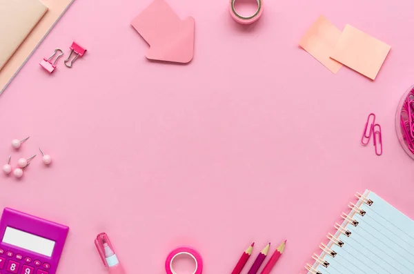 Bürotisch mit rosa Papeterie, Stiften, Bleistiften und einem Taschenrechner auf rosa Hintergrund. Minimaler Rahmen von oben mit Kopierraum — Stockfoto