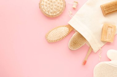 Plastiksiz ahşap bambu seti pembe arka planda yıkanmak için. Kopyalama alanı olan düz çerçeve