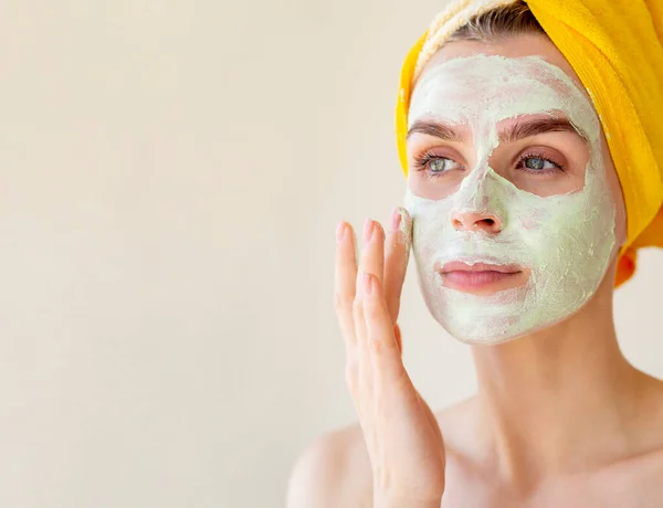 Mujer joven aplicando mascarilla facial de arcilla verde. Concepto de tratamientos de belleza con espacio de copia. Primer plano retrato — Foto de Stock