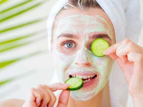 Topeng Wajah Buatan Alam. Foto close up dari Funny tersenyum Woman menerapkan hijau alami Facial Mask dengan irisan mentimun. Perawatan kecantikan. Topeng wajah, konsep perawatan kulit — Stok Foto