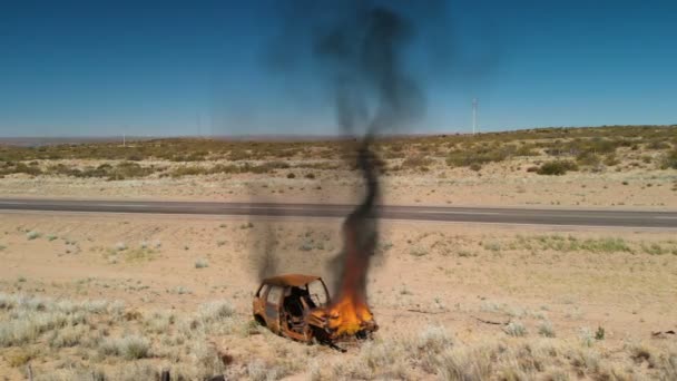 Bilen brinner nära vägen — Stockvideo