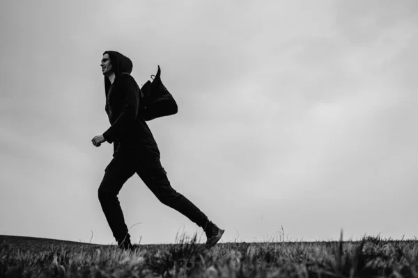 A lone man runs in a field.
