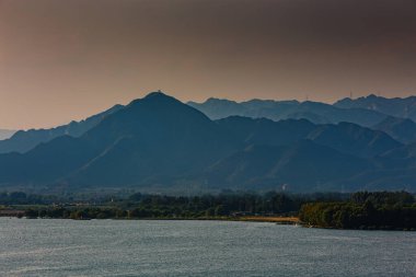 Güzel bir günbatımında dağlar ve göl.