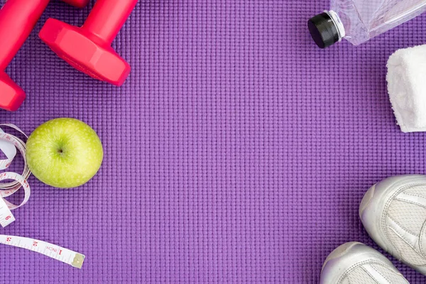 Fitness-Hintergrund mit Geräten über Yogamatte Stockbild