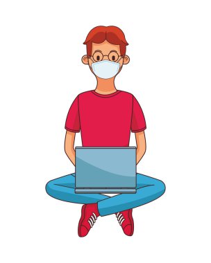 Genç adam tıbbi maske ve dizüstü bilgisayar kullanıyor.