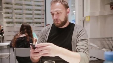 Adam tahriş olmuş. Adam onun smartphone gibi değil. Adam bir akıllı telefon elinde tutuyor. Modern teknoloji.